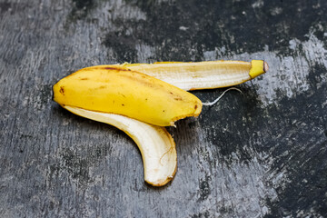 A peeled banana on a weathered concrete surface floor