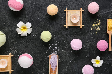 Bath bombs with sea salt, flowers and burning candles on dark background