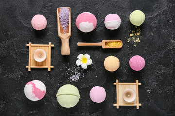 Bath bombs with sea salt, flower and burning candles on dark background