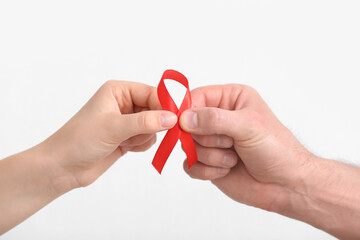 Hands with red ribbon on white background. Blood Cancer Awareness Month