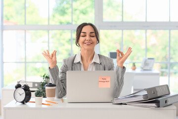Businesswoman meditating at table in office. Time management concept