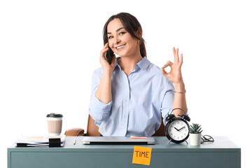 Businesswoman talking by mobile phone and showing OK at table on white background. Time management...