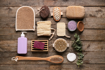 Composition with massage body brushes, sponges and bottle of cosmetic product on wooden background