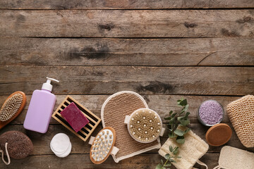 Composition with massage body brushes, sponges and bottle of cosmetic product on wooden background