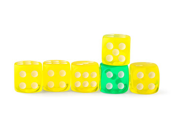 One green game dice among yellow ones on white background