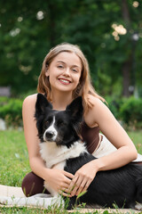Sporty young woman with cute Border Collie dog in park