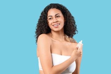Young African-American woman with giant Achatina snail on blue background