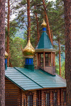 Wooden Church of St. Macarius of Altai in the village of Chemal among pine trees in Altai republic, Russia