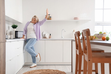 Mature woman dancing in kitchen