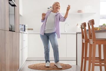 Mature woman dancing in kitchen