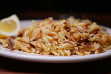 Delicious orzo pasta dish garnished with lemon