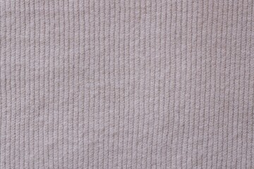 Texture of knitted pastel pink sweater, close-up texture of beige pink