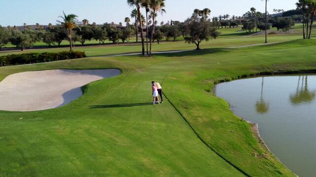 Golf instructor assisting female golfer on the course