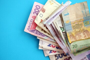 Ukrainian money bills on light blue paper background