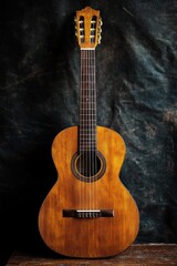 Obraz premium classic wooden acoustic guitar with six strings standing upright against a dark textured background evoking a warm and rustic atmosphere