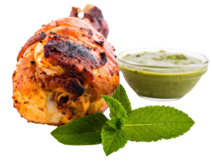 Roasted Tandoori chicken drumstick with charred skin mint sauce and a fresh mint sprig.