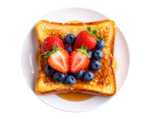Golden French toast topped with fresh strawberries blueberries and sweet syrup.