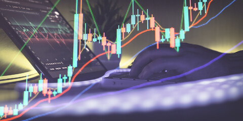 Person working at night with a tablet and calculator, viewing colorful candlestick charts for stock or crypto market trading.