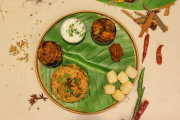 South indian thali food with sambhar and different types of chutney served on banana leaf