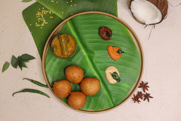 Mysore bonda served in a banana leaf with different kinds of chutney