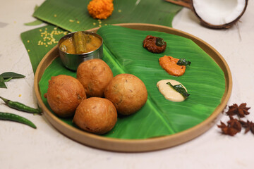Mysore bonda served in a banana leaf with different kinds of chutney