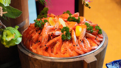 Beautiful sweet shrimp arranged in a tank Decorated with lemons and vegetables at a banquet hall in a luxury hotel.