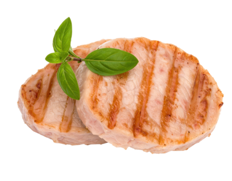 Two appetizing grilled pork loin medallions with char marks and fresh basil garnish.