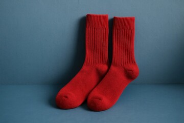 A pair of vibrant red socks resting on a blue background