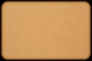 blank backdrop: close up of beige cardboard with rounded corners against black background