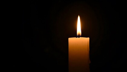 Single candle flame against a dark background.