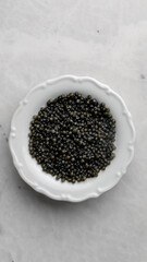 Glistening black mustard seeds in delicate porcelain bowl, culinary alchemy for Diwali spice rituals and winter solstice traditions