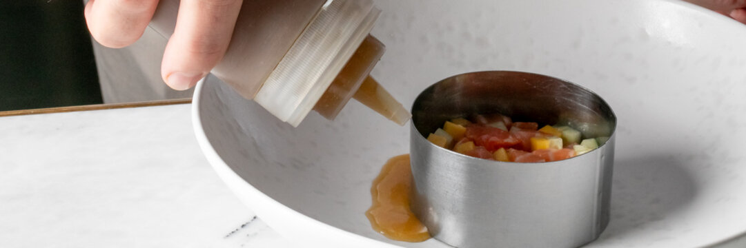 Squeezing a tangy elixir onto diced nectar in a culinary ring, gastronomic artistry, coinciding with National Chefs Day