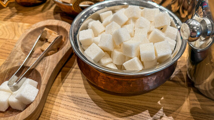 Sugar cubes elegantly nested in antique dish, embodying sweet symphony at Victorian tea time or National Sugar Cookie Day
