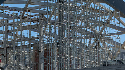 Obraz premium Under a cobalt sky, intricate scaffolding resembles a metallic web, celebrating International Workers' Day and the festival of Diwali