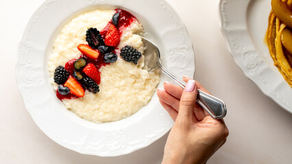 A delicate breakfast scene with diverse berries on creamy porridge, evoking Nordic midsummer and Hygge warmth
