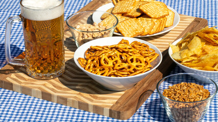Crisp pretzels and beer glisten under Oktoberfest sunlight, echoing German camaraderie, pub storytelling, and rustic autumn indulgence
