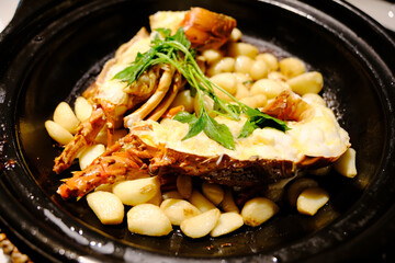 garlic lobster with garlic cloves in black pot
