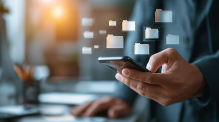 Businessman using smartphone with digital file folder icons

