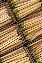 matches in matchbox, the green head of a wooden match laid out in cardboard boxes, closeup, top view