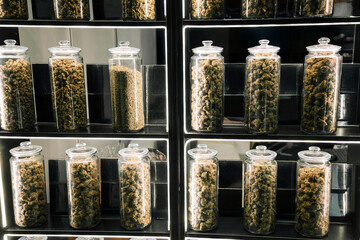 Cannabis buds in glass jars on dispensary shelf