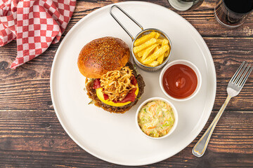 Delicious gourmet burger with cheddar cheese, fried onions, coleslaw and fries