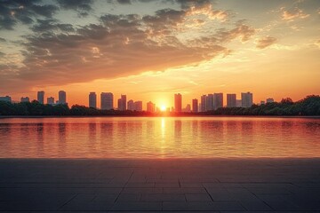 Sunset over a city skyline with tall buildings reflected in a calm body of water under a dramatic cloudy sky