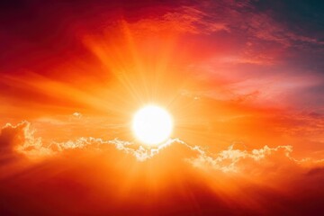 Bright sun shining through scattered clouds in a vibrant red and orange sky, creating a warm and dramatic sunrise or sunset scene