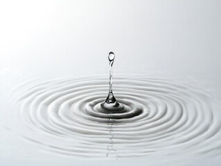 Single water droplet rising above the surface with concentric ripples spreading outward in calm water
