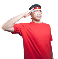 Fototapeta premium Indonesian men wearing red shirt, flag headband and Indonesian flag sticker on cheek giving salute celebrate Indonesian independence day on August 17 isolated over white background