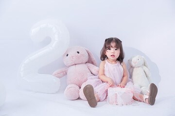 Two-Year-Old's Birthday Celebration: Captivating shot of a adorable two-year-old girl surrounded by...