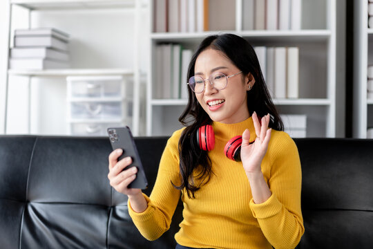 Asian Woman Video Calling On Smartphone At Home Happy Adult Female Using Mobile Phone For Online Communication And Entertainment Smiling