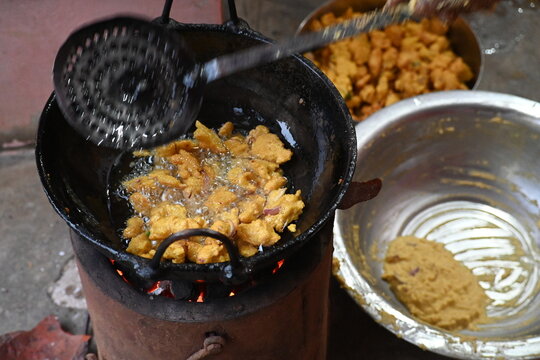 Onion pakora frying in iron pen. This is a popular street food in Indian subcontinent. Onion which are coated in seasoned&nbsp;spicy gram flour&nbsp;batter and deep fried. It originated in India.
