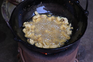 Onion pakora frying in iron pen. This is a popular street food in Indian subcontinent. Onion which...