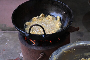 Onion pakora frying in iron pen. This is a popular street food in Indian subcontinent. Onion which...